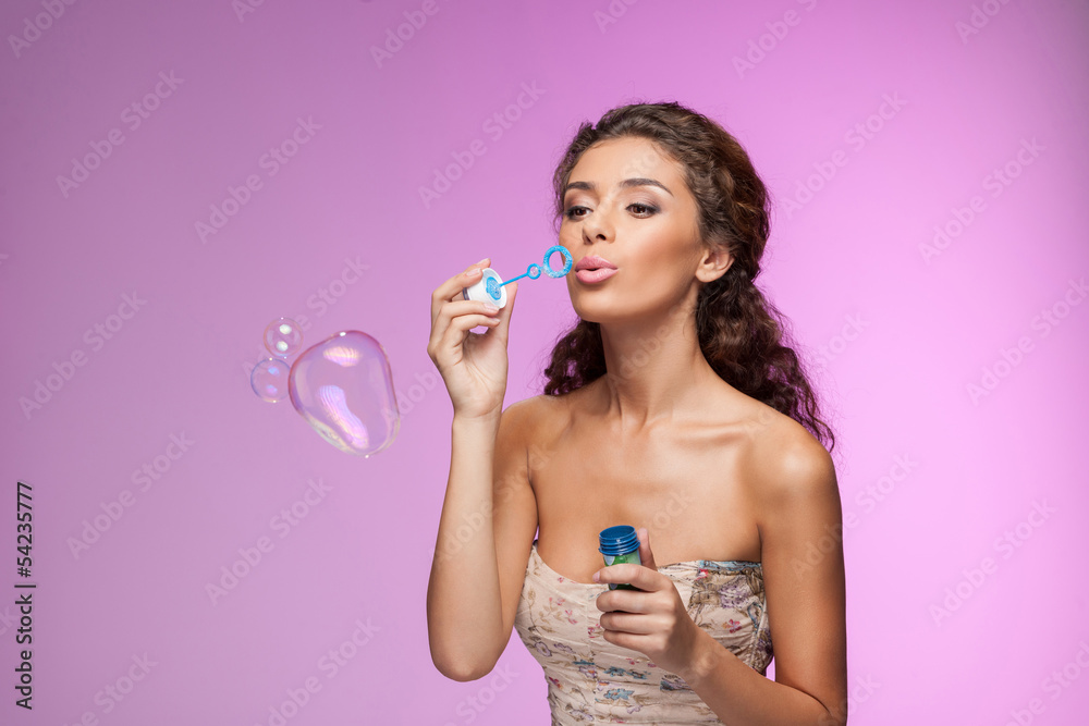 Beauty with bubble wand. Beautiful young women blowing into the Beauty with bubble wand. Beautiful young women blowing into the