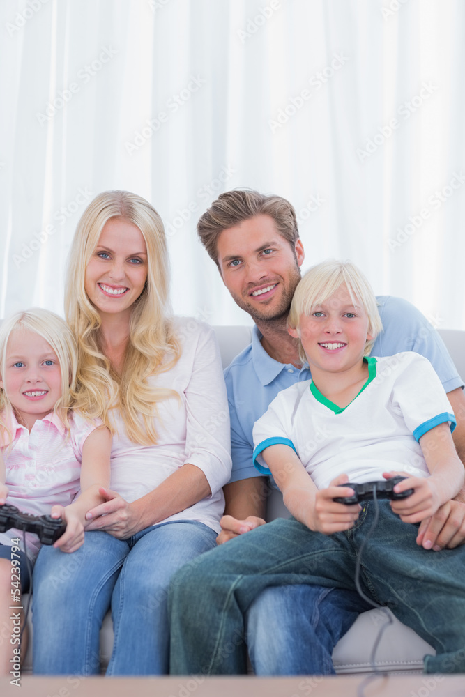 Family sitting on couch playing video games Family sitting on couch playing video games