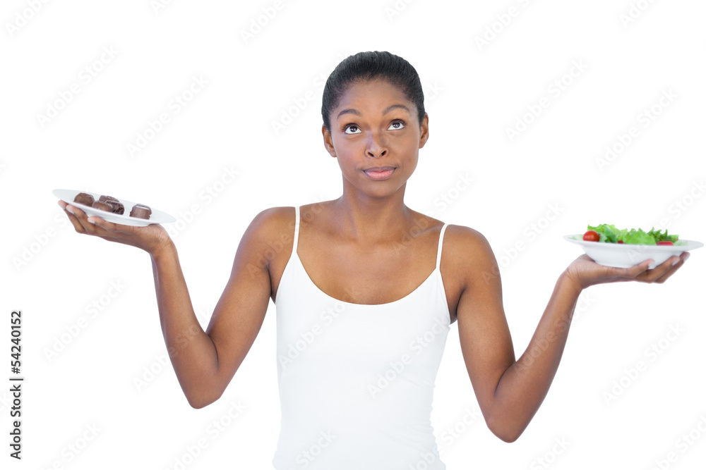 Conflicted woman deciding to eat healthily or not Conflicted woman deciding to eat healthily or not