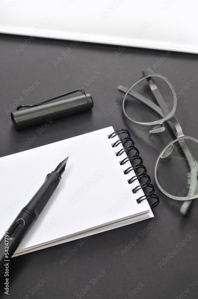 Fototapeta premium Eye glasses, blank notepad, and pen, on the table