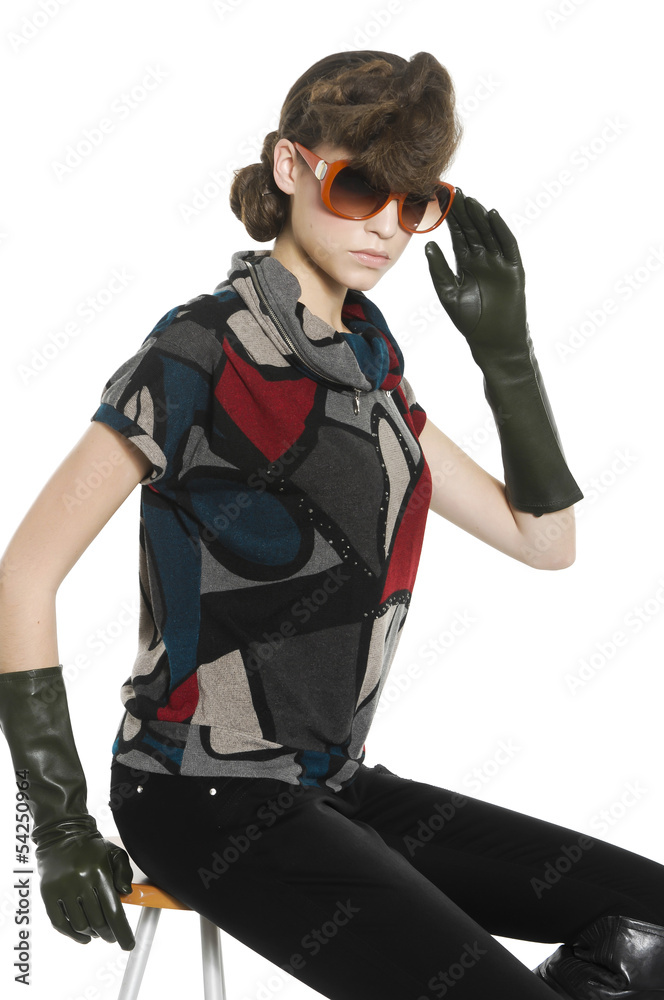 Fashion woman in sunglasses sitting on chair. Studio shot Fashion woman in sunglasses sitting on chair. Studio shot