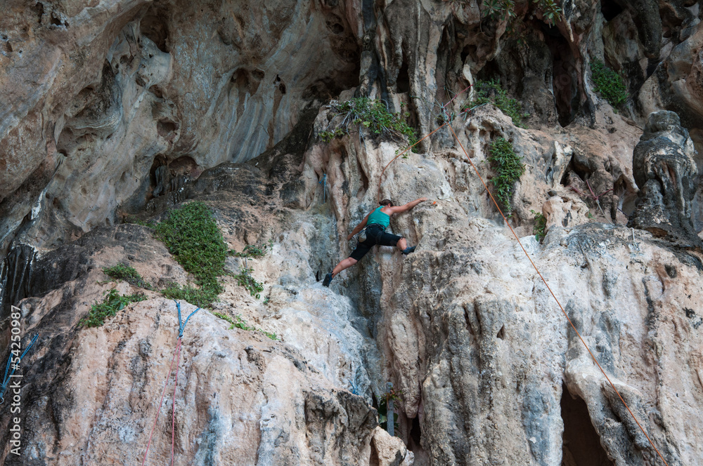 Woman climbing on the rock route summer (Railay Beach, Krabi pro
