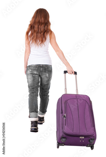 back view of walking woman with suitcase