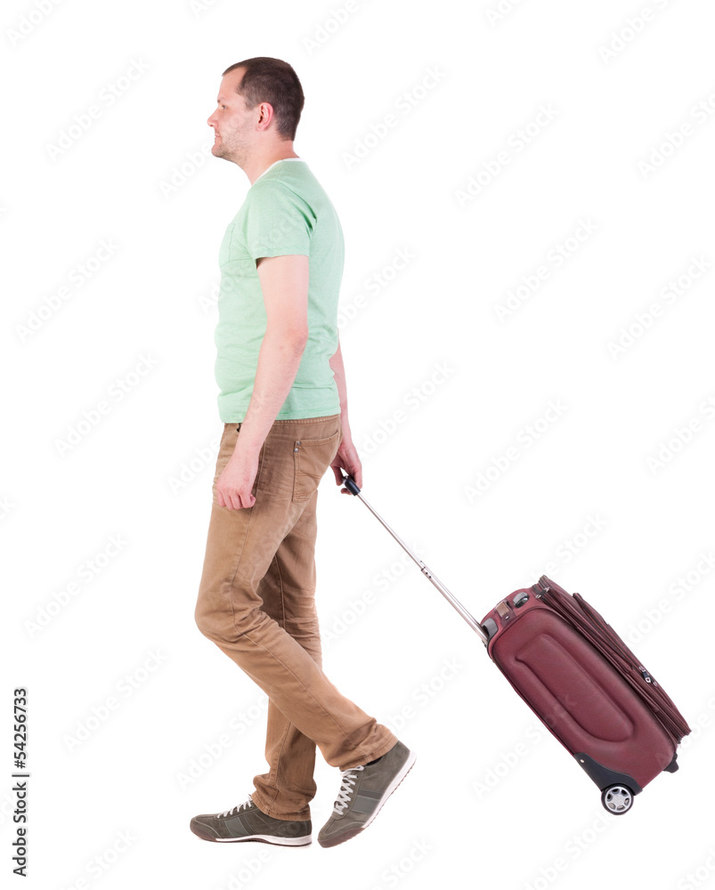 back view of walking man with suitcase. brunette guy in motio back view of walking man with suitcase. brunette guy in motio