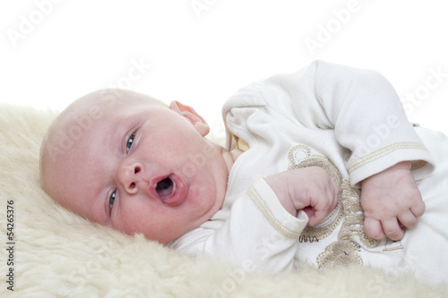 Baby on a sheepskin. Baby is three month old. Studiolight with white background