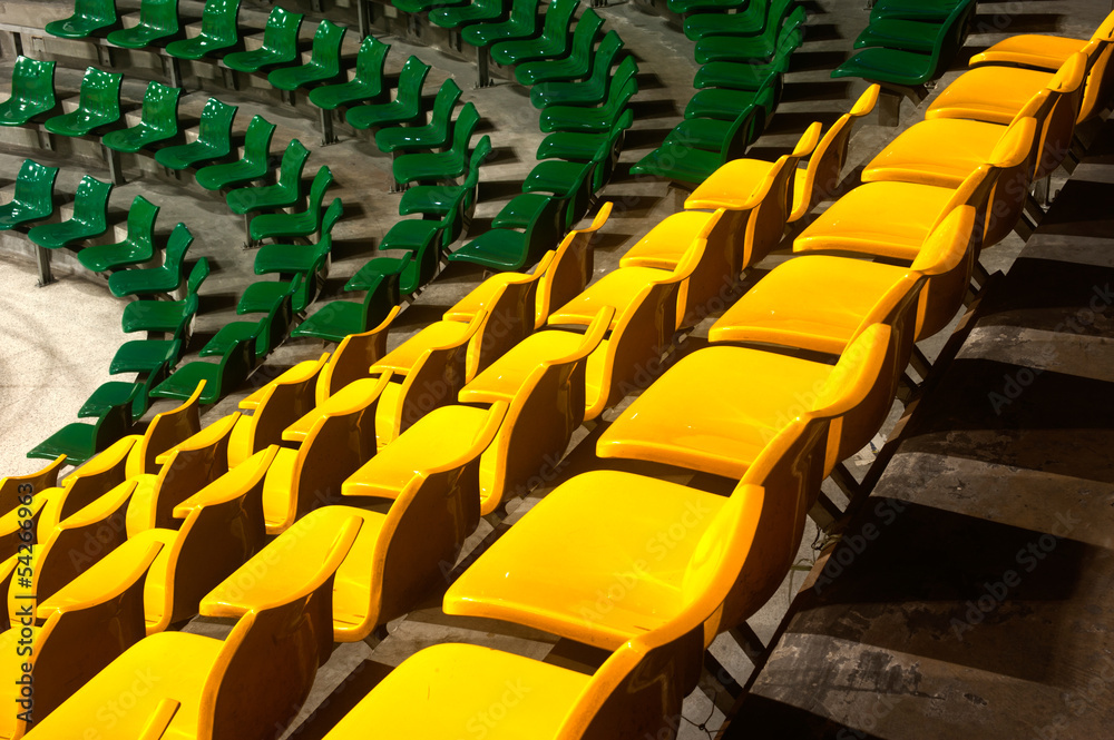 Fototapeta premium Plenty of yellow and green plastic seats at stadium .
