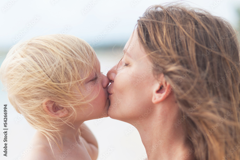 Mother and little daughter kissing on the beach Mother and little daughter kissing on the beach