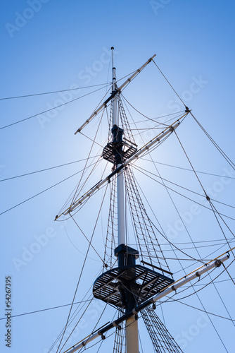 Mast of the sail boat on the blue sky background with sunlight