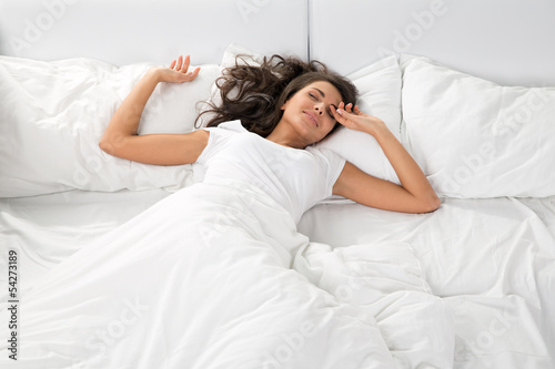 young woman sleeping on the white linen in bed