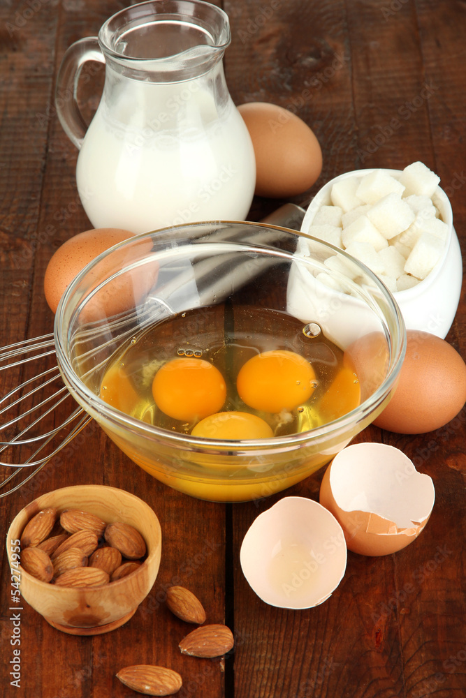 Broken egg in bowl and various ingredients next to them Broken egg in bowl and various ingredients next to them