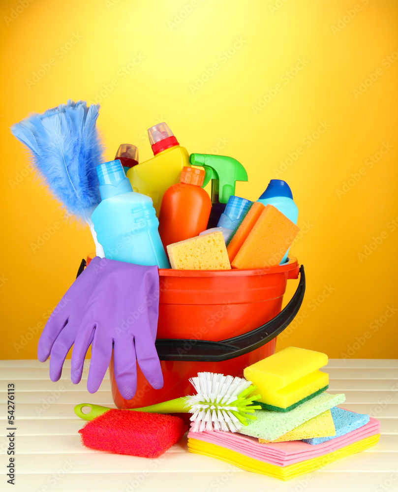 Cleaning items in bucket on color background Cleaning items in bucket on color background