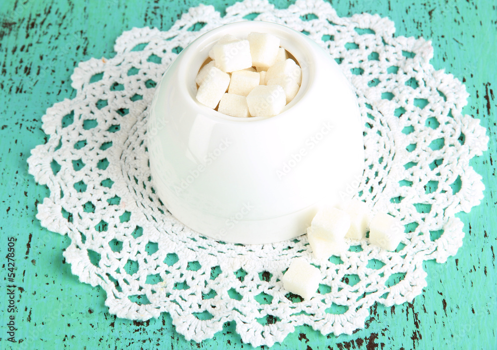 Refined sugar in white sugar bowl on wooden background Refined sugar in white sugar bowl on wooden background