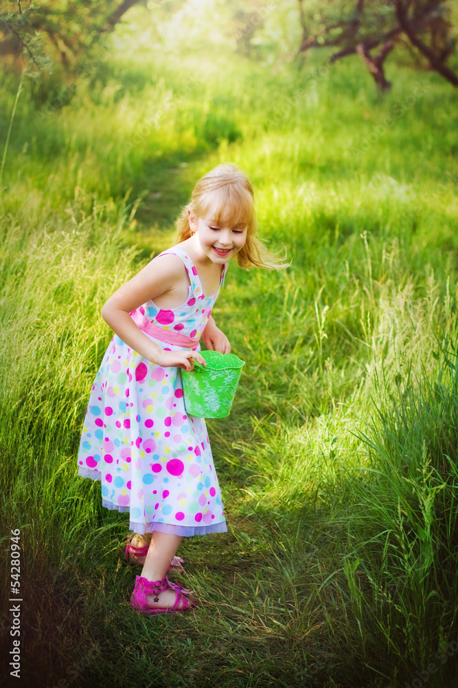 Portrait of happy little girl with a bucket in a summer park Portrait of happy little girl with a bucket in a summer park