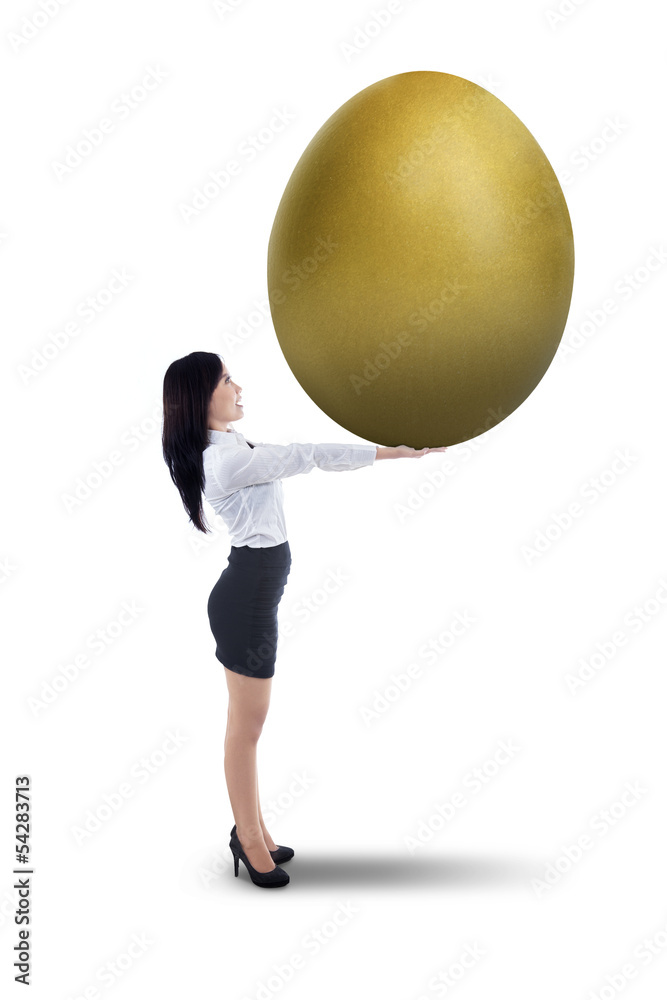 Attractive businesswoman holding big golden egg - isolated Attractive businesswoman holding big golden egg - isolated