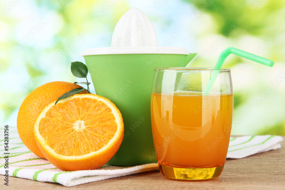Naklejka premium Citrus press, glass of juice and ripe oranges