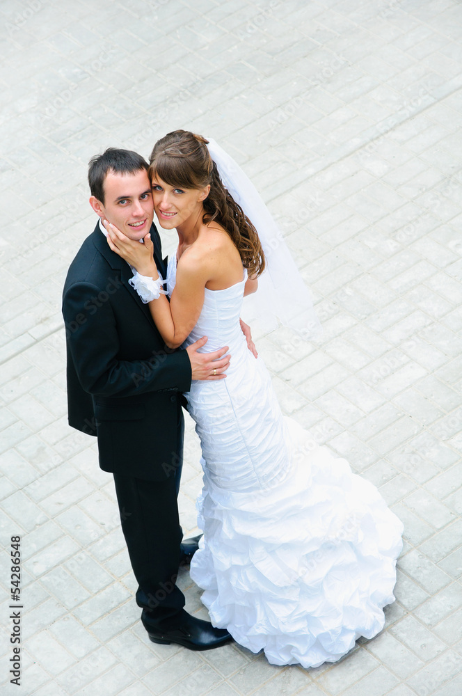 Naklejka premium happy wedding couple standing and embracing