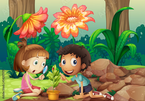 A girl and a boy looking at the plant with a magnifying glass