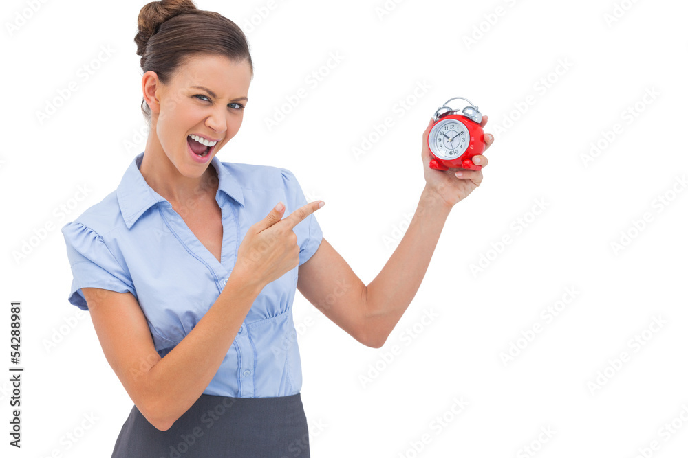 Businesswoman pointing at alarm clock Businesswoman pointing at alarm clock