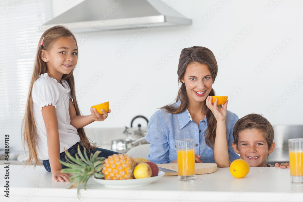 Siblings raising a half orange in the kitchen Siblings raising a half orange in the kitchen