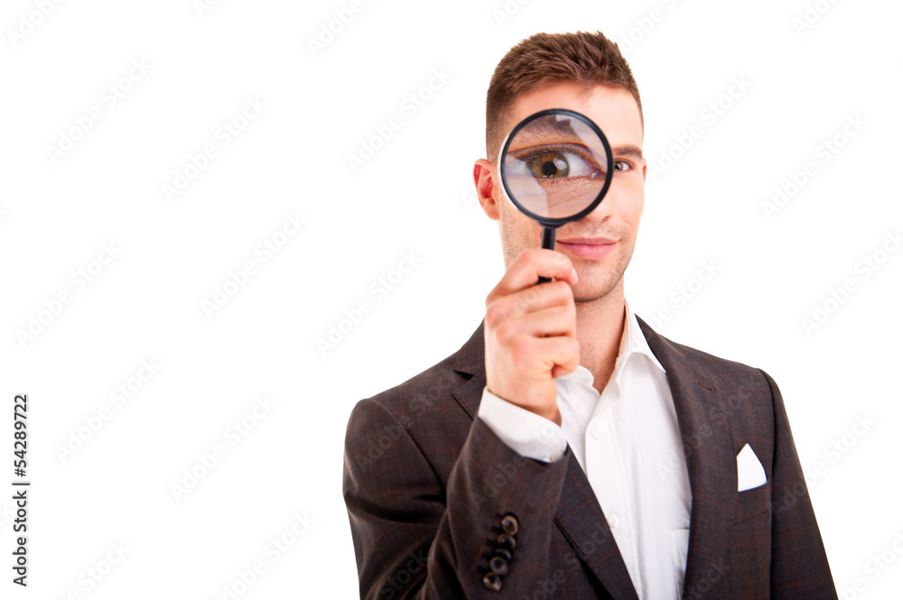 Young business man in suit looking to magnifying glass Young business man in suit looking to magnifying glass