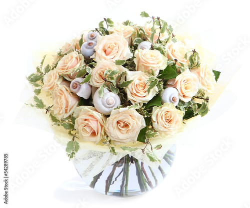 Flower arrangement with cream roses and shells, glass vase. © grigvovan