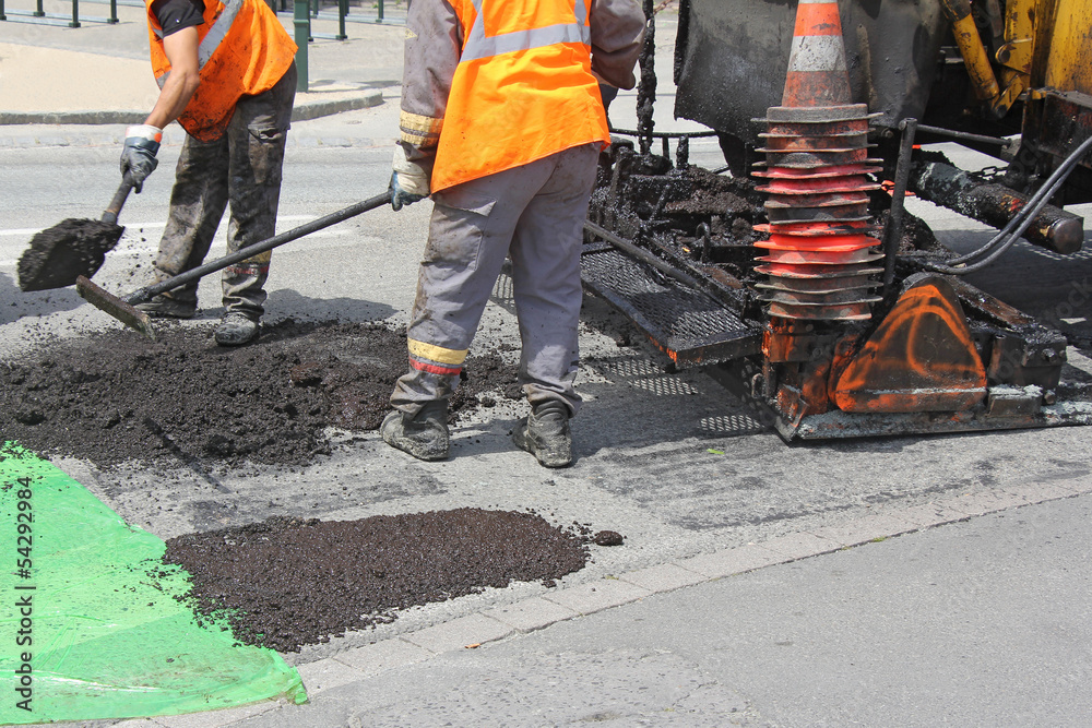 Workers on Asphalting paver machine during Road street repairing works Workers on Asphalting paver machine during Road street repairing works