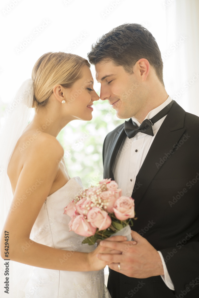 Bride And Groom With Flower Bouquet Rubbing Noses Bride And Groom With Flower Bouquet Rubbing Noses