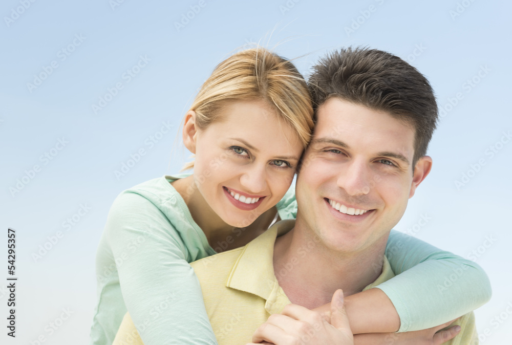 Woman Embracing Man From Behind Against Clear Blue Sky Woman Embracing Man From Behind Against Clear Blue Sky
