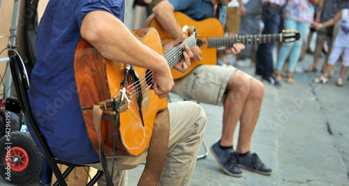 artisti di strada con chitarra, con pubblico sullo sfondo photo