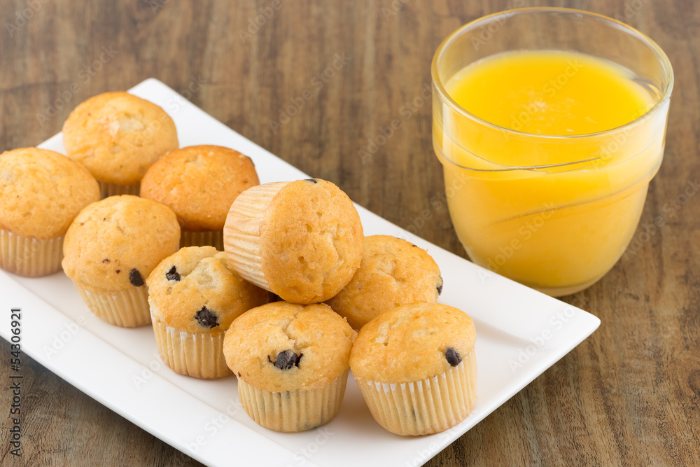 fresh chocolate chip muffins with a glass of orange juice fresh chocolate chip muffins with a glass of orange juice