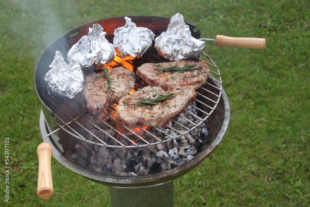 Grill mit Grillfleisch mit Rosmarin und Folienkartoffeln Stock Photo ...
