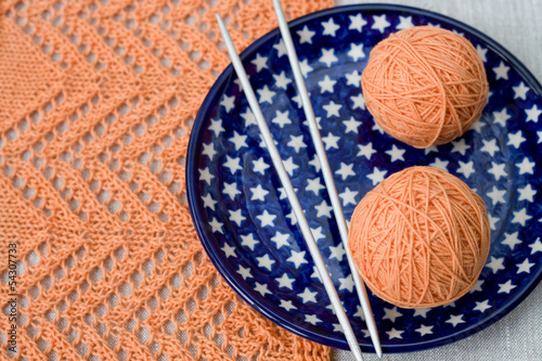 Orange balls, knitted pattern and knitting nedles
