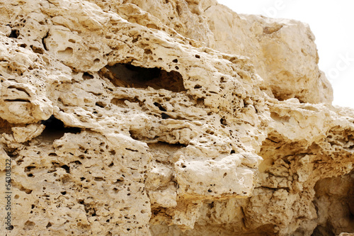 Pores visible in the outcrops of weathered limestone rock photo