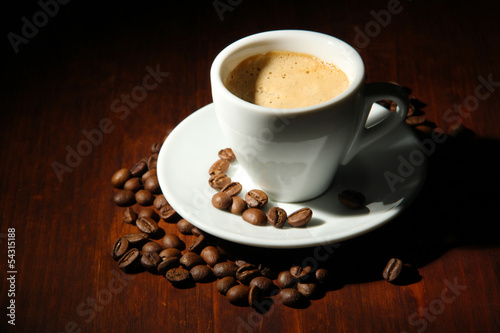 Fototapeta Naklejka Na Ścianę i Meble -  Cup of coffee with coffee beans on wooden background