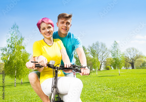 Bild auf Leinwand Smiling couple on the bike