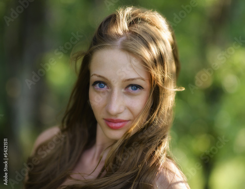 Portrait of young attractive woman at summer green park.