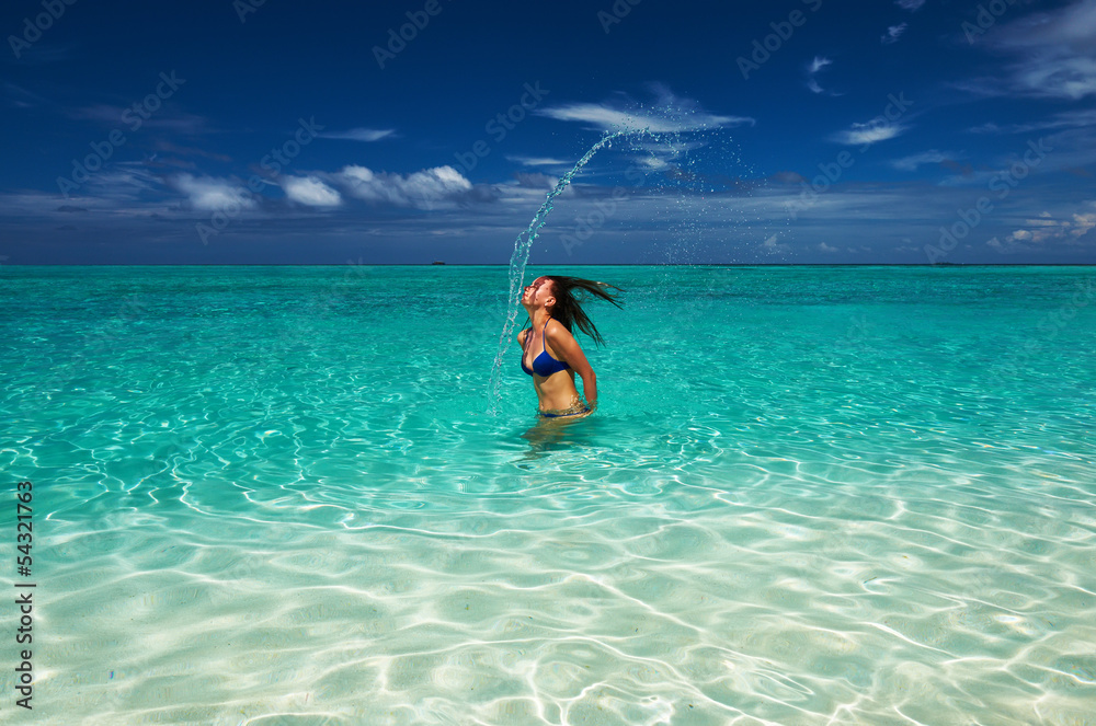 Woman splashing water with hair in the ocean Woman splashing water with hair in the ocean