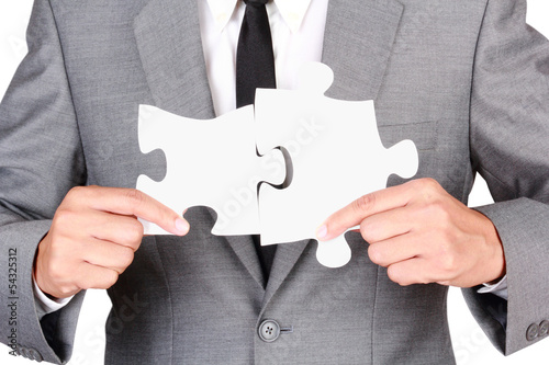 Businessman holding mismatch jigsaw photo