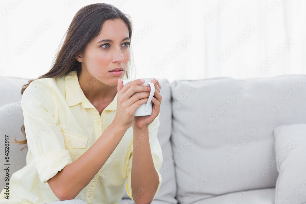 Thoughtful woman holding a cup of coffee Thoughtful woman holding a cup of coffee