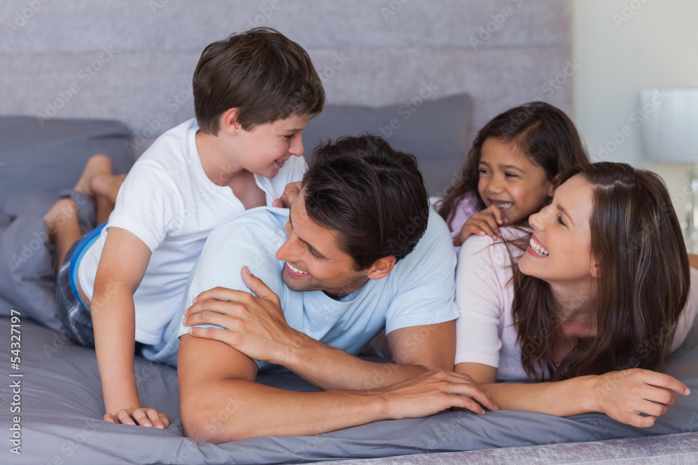 Happy family having fun on the bed Happy family having fun on the bed