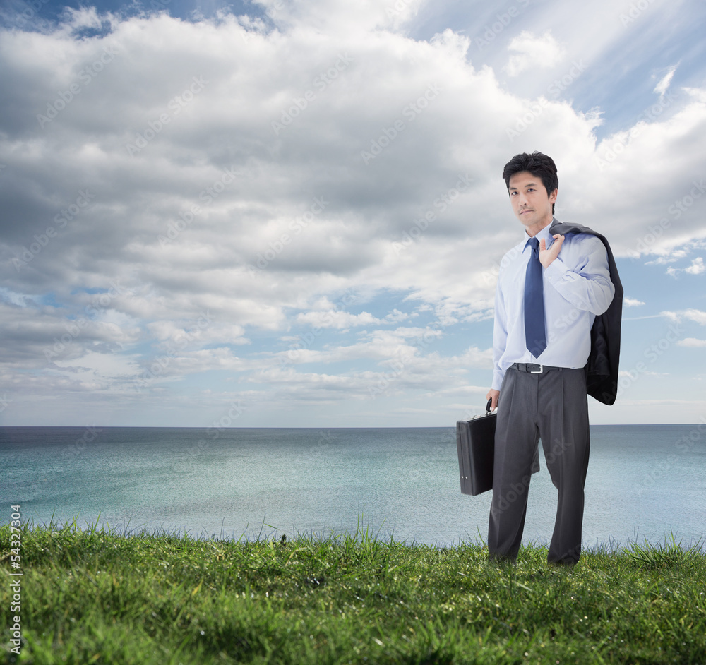 Elegant businessman holding briefcase and his jacket over his sh Elegant businessman holding briefcase and his jacket over his sh
