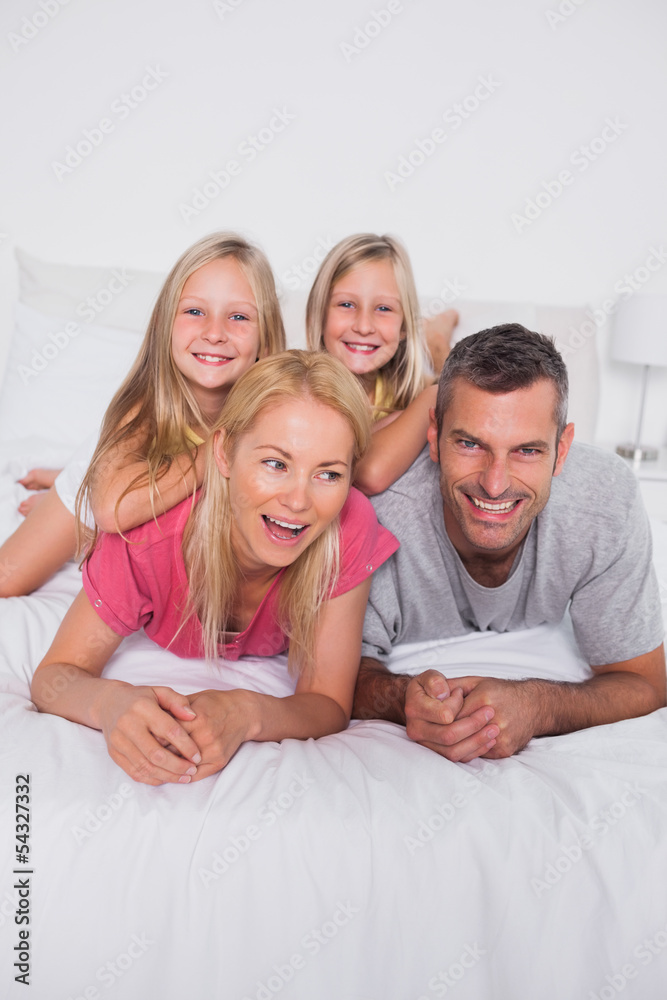 Parents lying in bed with their twins