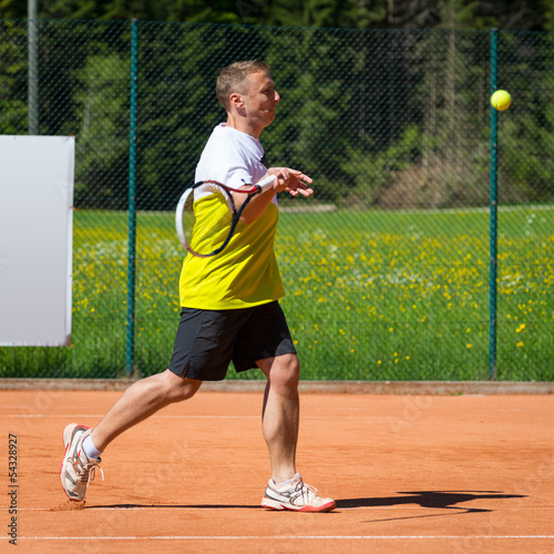 side view of tennis player hitting a forehand