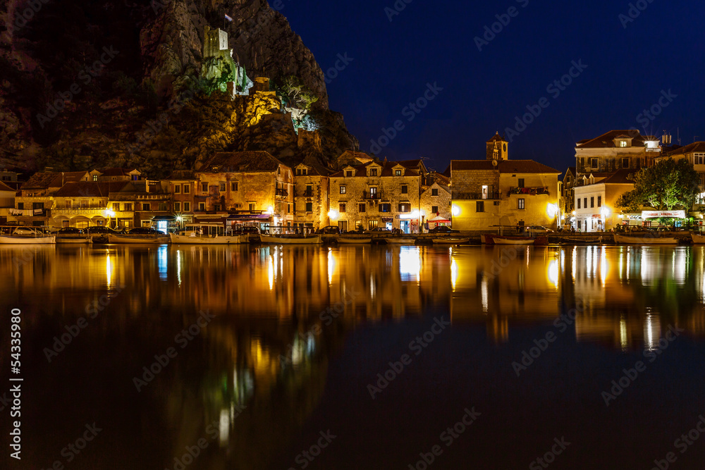 Illuminated Pirate Castle and Town of Omis Reflecting in the Cet