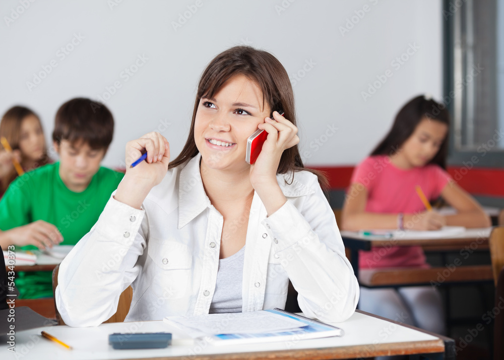 Female Student Looking Away While Using Mobilephone Female Student Looking Away While Using Mobilephone