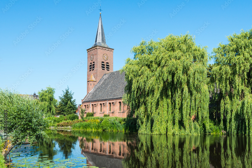 Dutch church at a river in summer