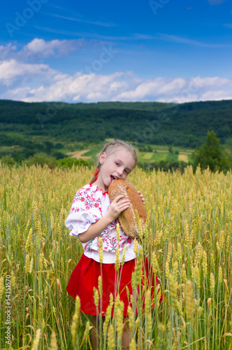 Girl with bread in the wheat field