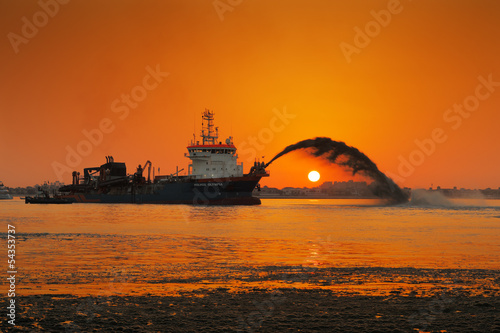 A dredging ship in action at Palm Jumeirah, Dubai, UAE photo