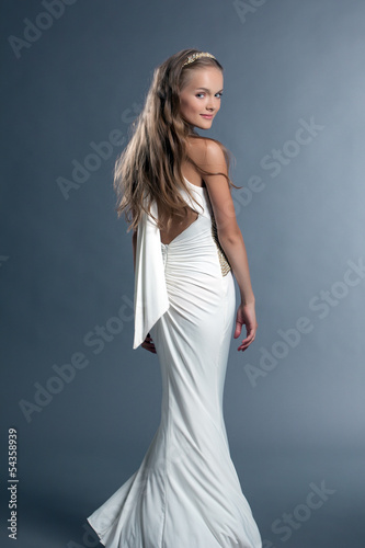 Smiling young girl posing in white cocktail dress