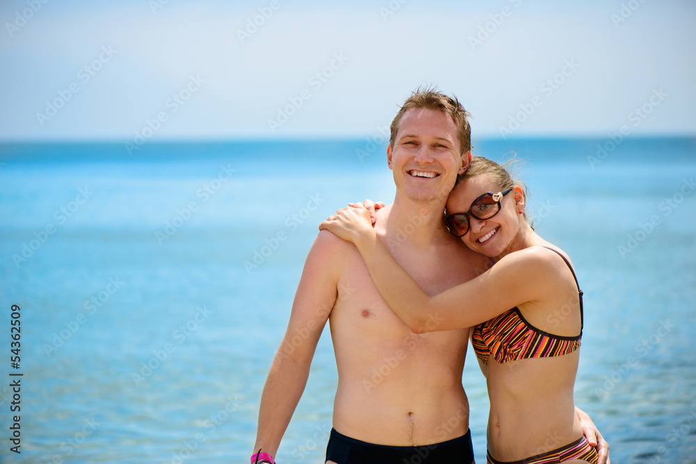 Young man and beautiful girl smiling at ocean beach Young man and beautiful girl smiling at ocean beach